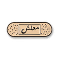 Beige enamel bandage-shaped metal brooch with black Arabic calligraphy