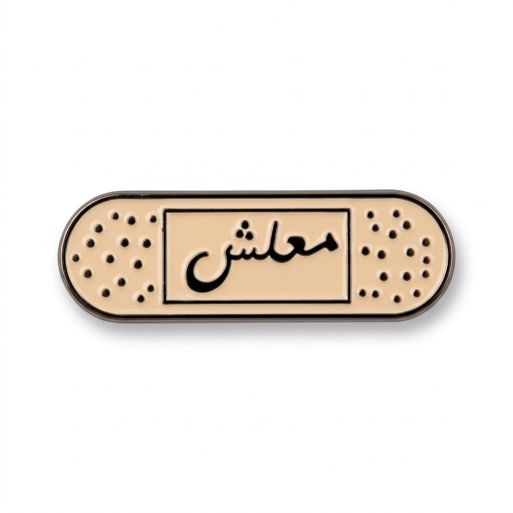 Beige enamel bandage-shaped metal brooch with black Arabic calligraphy