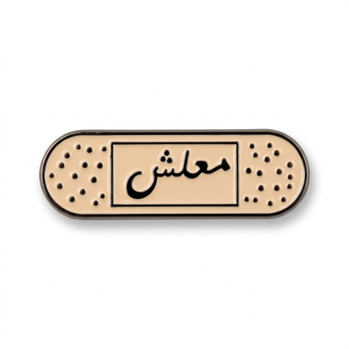 Beige enamel bandage-shaped metal brooch with black Arabic calligraphy